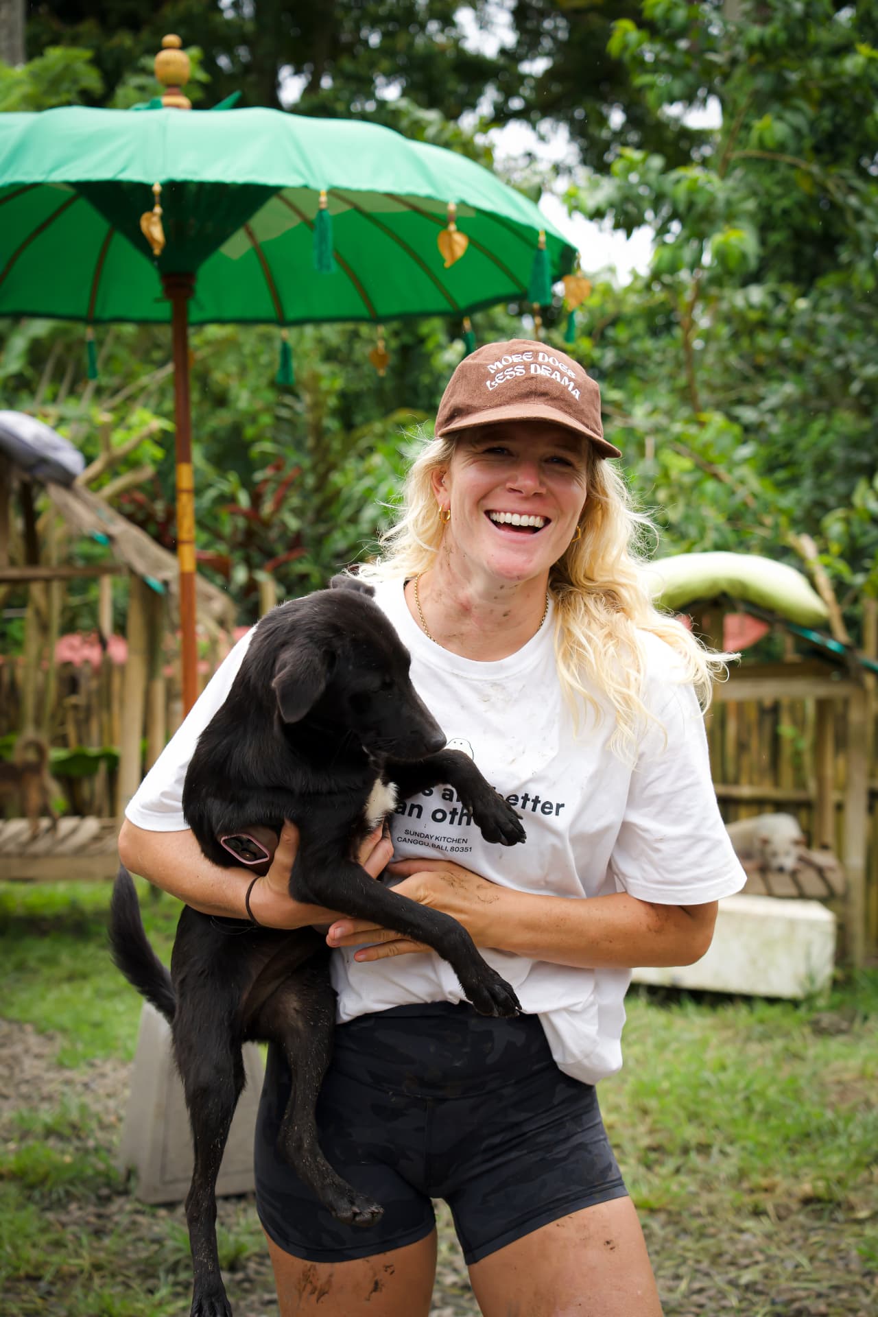 Lizzie laughing while holding one of her rescue puppies in Bali