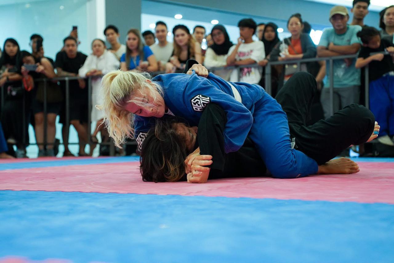 Lizzie competing in a jiu jitsu match in a blue gi